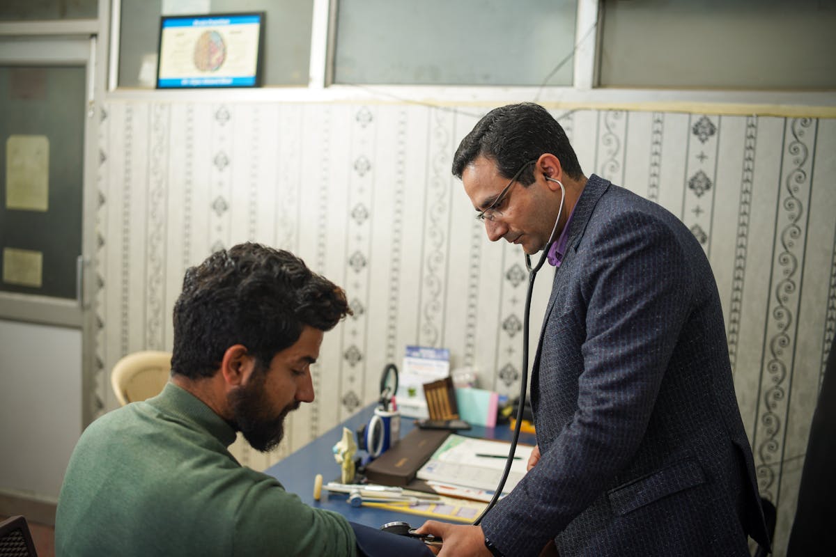 Indian doctor with a stethoscope examining a patient in a Qatar hospital, degree attestation and certified Arabic