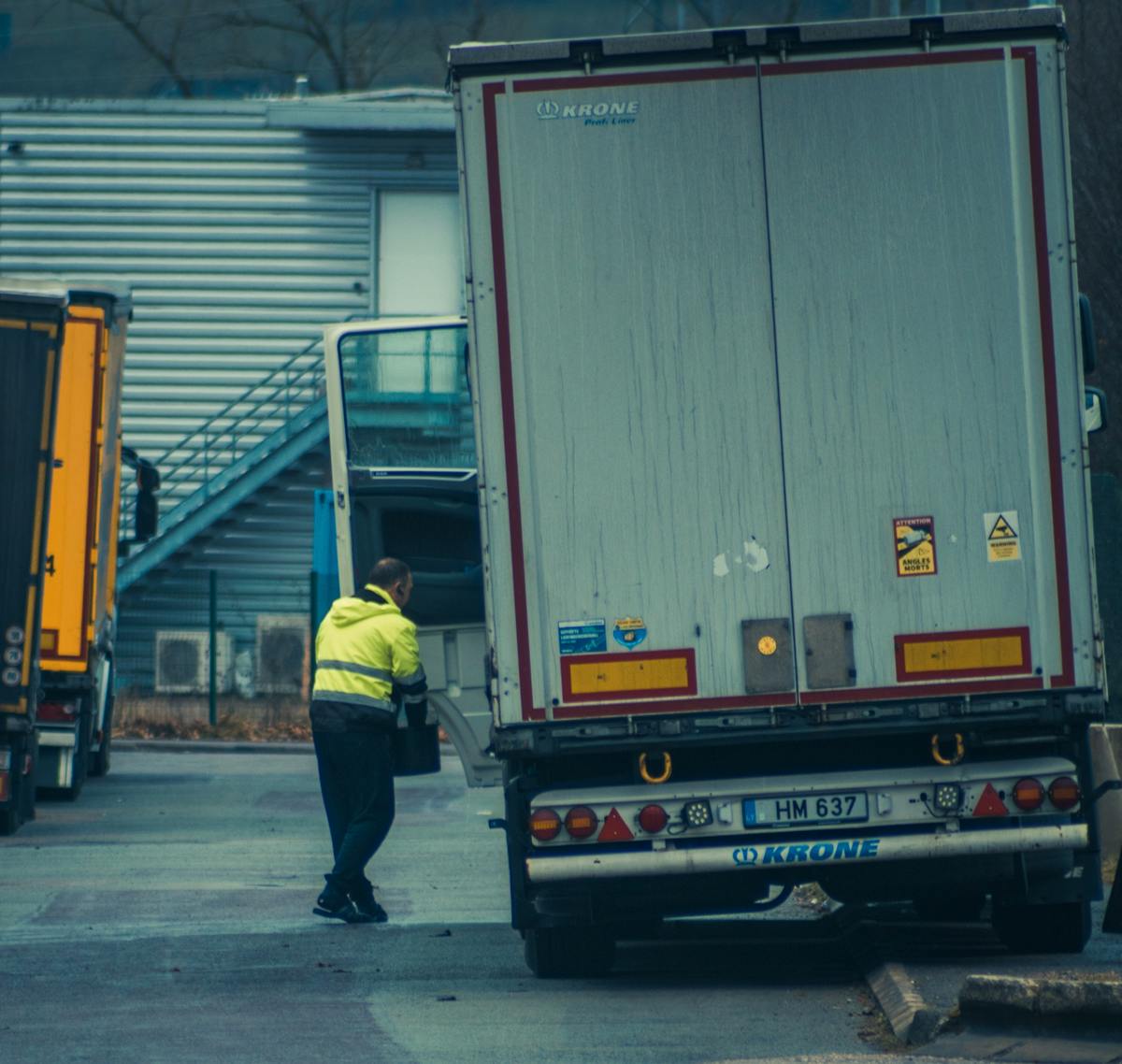 Indian heavy truck driver loading cargo at a Saudi logistics hub, the kind of driver whose Indian licence and experience