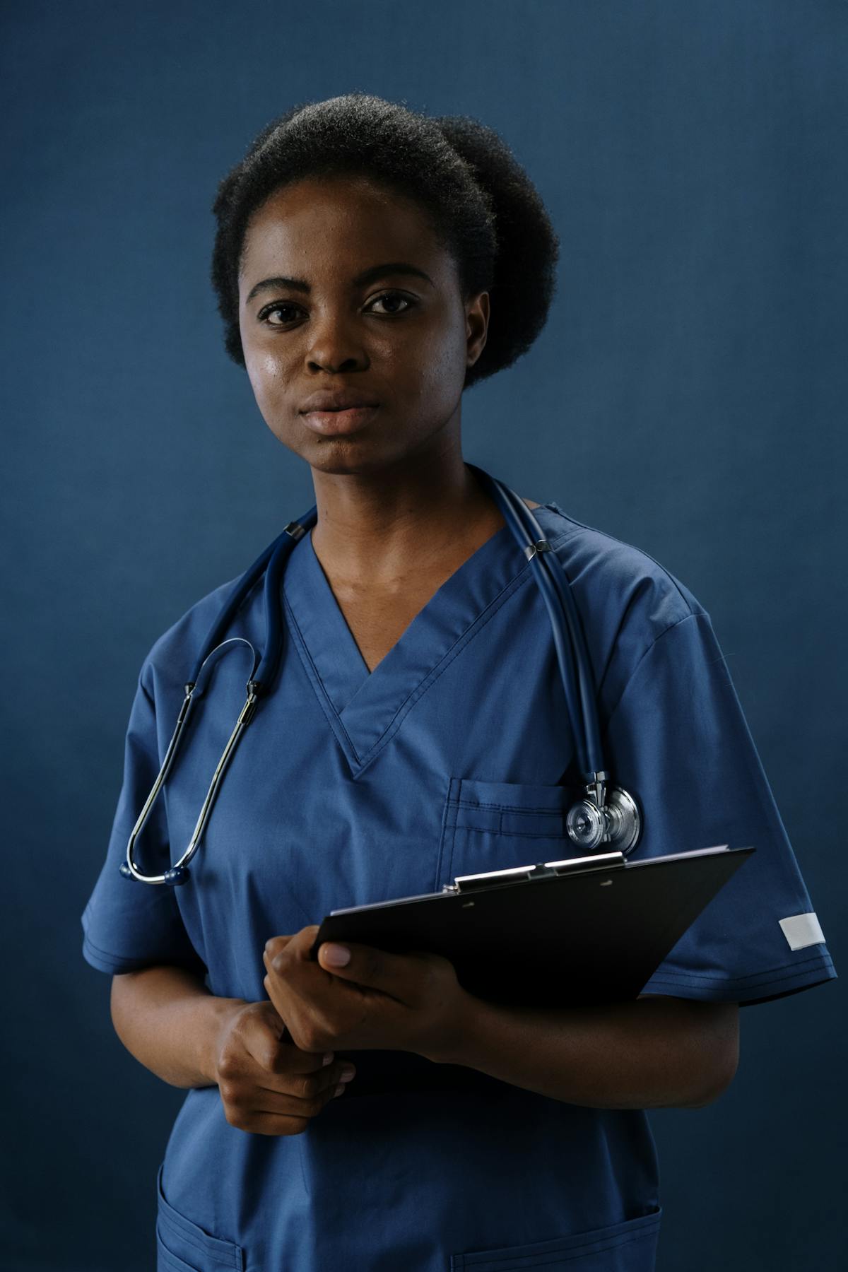 Indian nurse holding a clipboard at a Kuwait clinical workstation, nursing degree and council card ready for Kuwait MOH