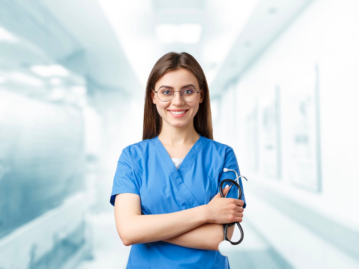 Indian nurse in blue scrubs at the bedside on a Saudi hospital ward