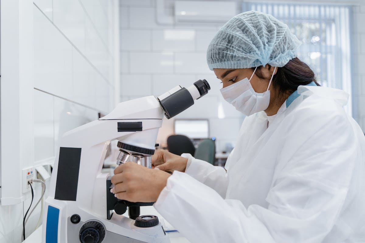 Indian postdoctoral researcher using a microscope in a UK university lab