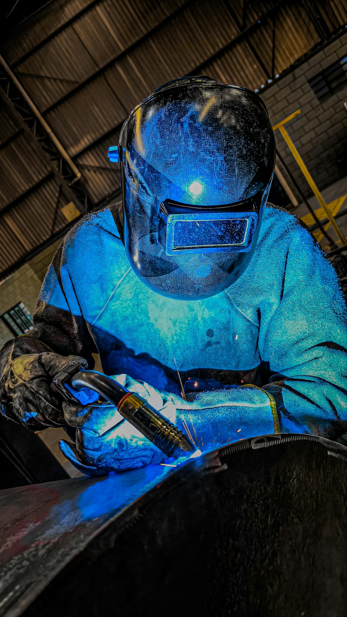Indian welder in protective gear working at a Saudi construction site