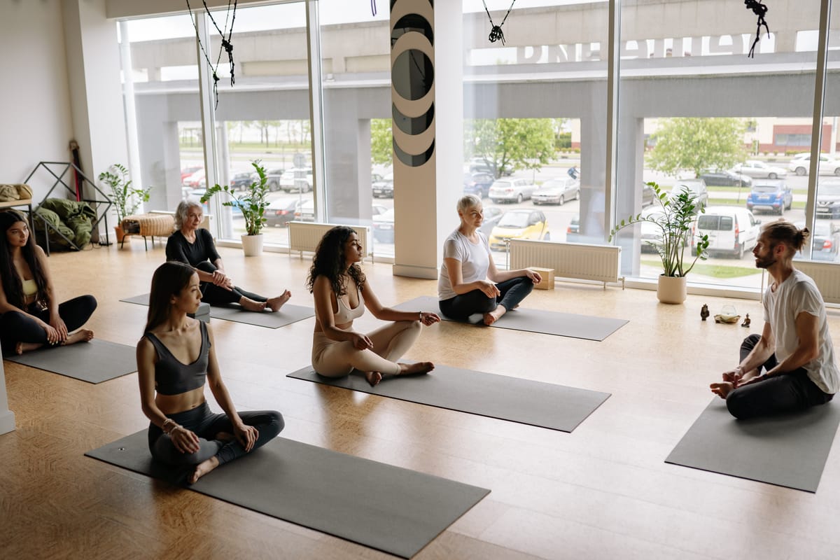 Indian yoga teacher leading a wellness retreat class, whose YCB certificate and yoga teacher training certificate need
