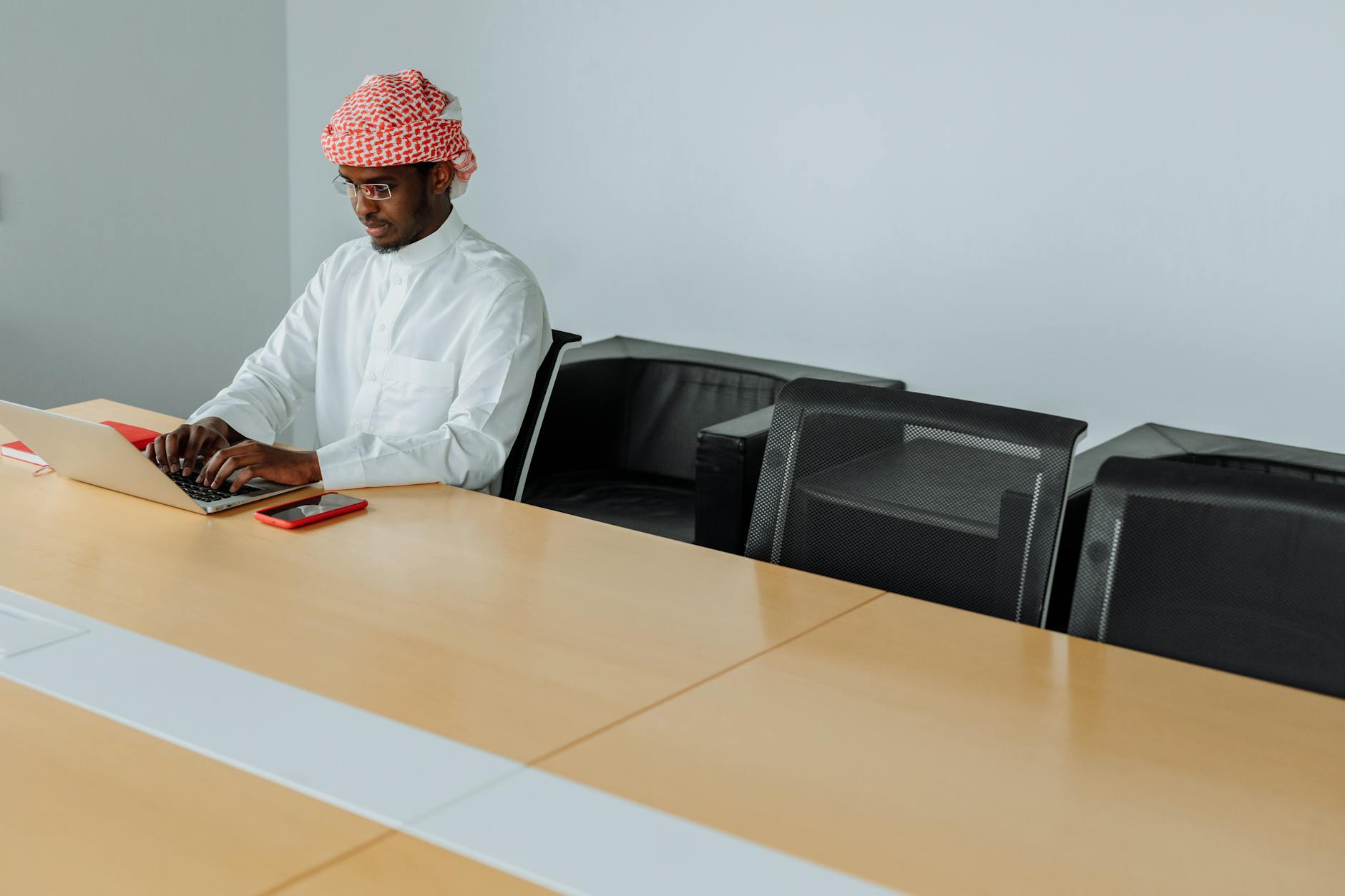 Indian professional in traditional Middle Eastern setting reviewing Qatar employment visa documents, including QID and